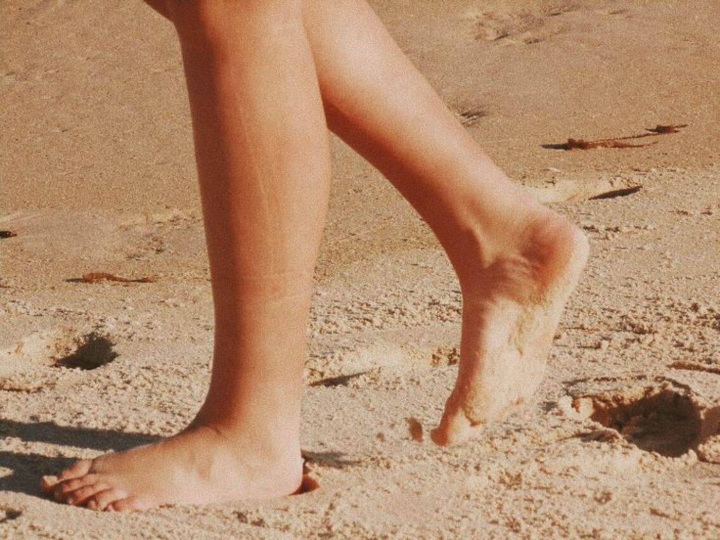 Bare feet walking on warm sand